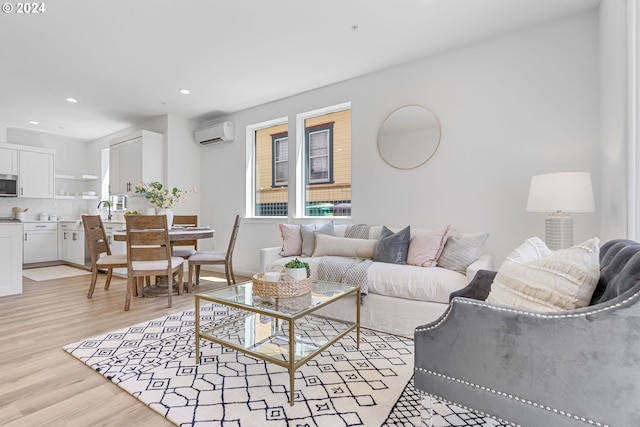 living room featuring a wall mounted air conditioner, sink, and light hardwood / wood-style flooring