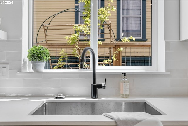 interior details featuring decorative backsplash and sink