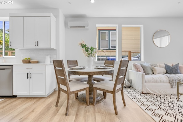 dining room with light hardwood / wood-style floors and a wall mounted air conditioner