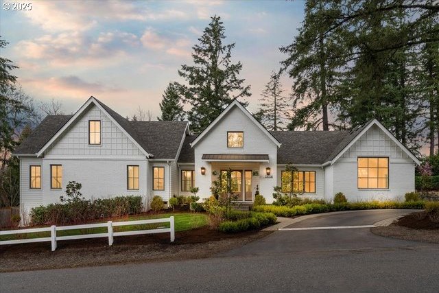 modern farmhouse style home with fence and asphalt driveway