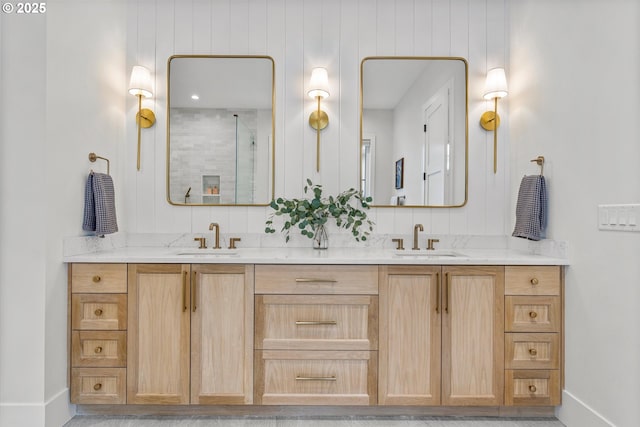 full bathroom featuring double vanity, baseboards, and a shower with shower door