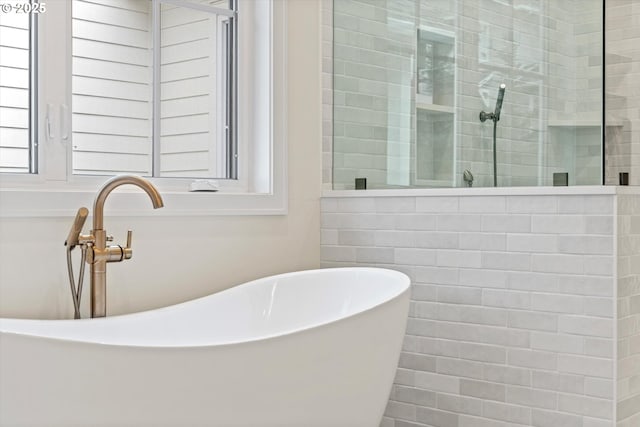 full bathroom with a tile shower, a sink, and a soaking tub