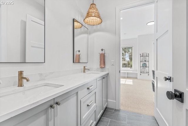 full bath featuring double vanity and baseboards