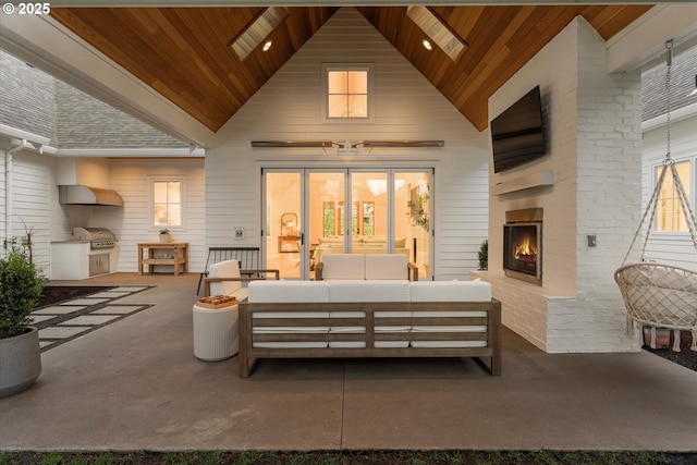 view of patio / terrace with an outdoor kitchen, an outdoor living space with a fireplace, and area for grilling
