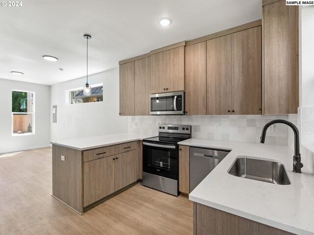 66 NE Stanton St, Portland, OR 97212 - kitchen with hanging light fixtures, decorative backsplash, sink, and stainless steel appliances