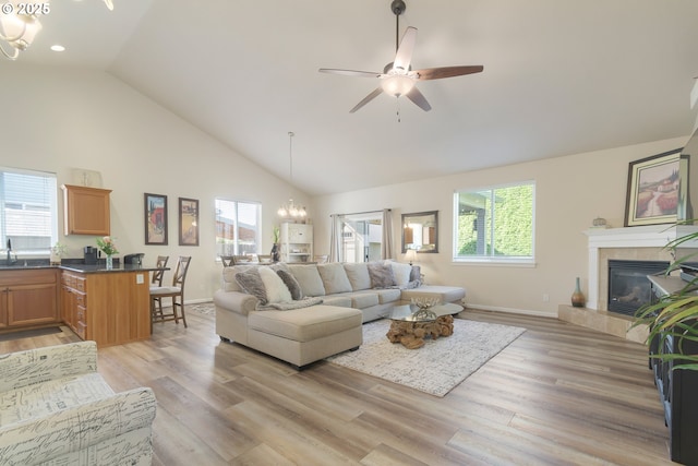 1281 Alderdale Dr, Junction City, OR 97448 - living room featuring a chandelier, healthy amount of natural light, a fireplace, light wood finished floors, and high vaulted ceiling