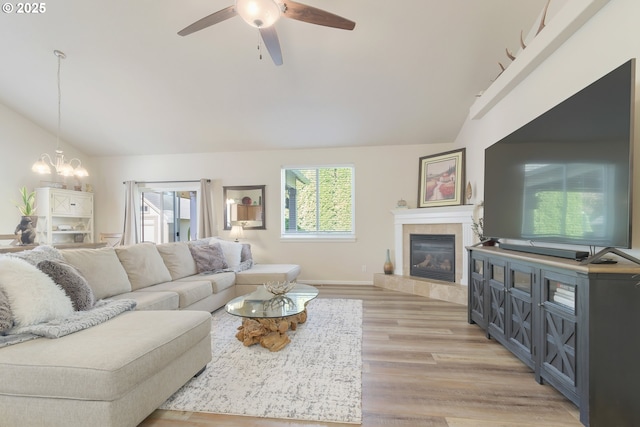1281 Alderdale Dr, Junction City, OR 97448 - living room with vaulted ceiling, a ceiling fan, a fireplace, a chandelier, and light wood-style flooring