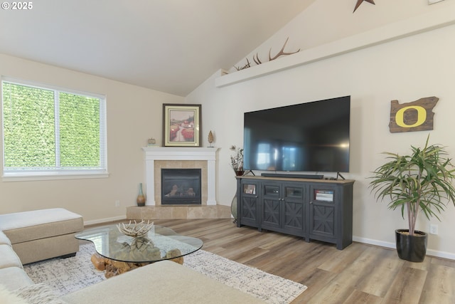 1281 Alderdale Dr, Junction City, OR 97448 - living area with wood finished floors, a tiled fireplace, baseboards, and high vaulted ceiling