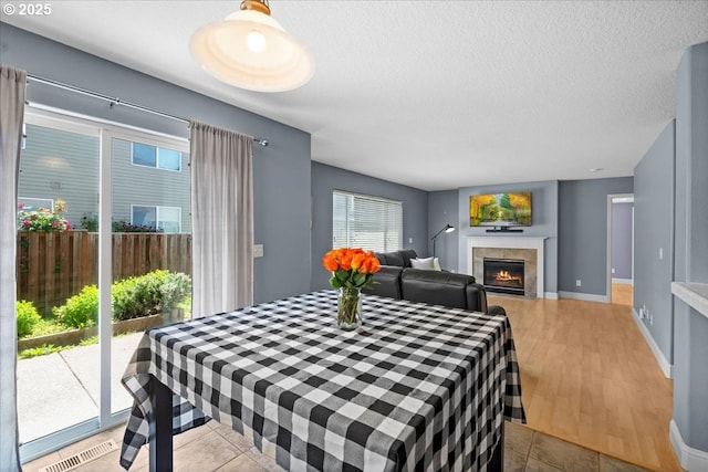5836 NE Farnham St, Hillsboro, OR 97124 - dining space featuring a textured ceiling, a fireplace, wood finished floors, and baseboards