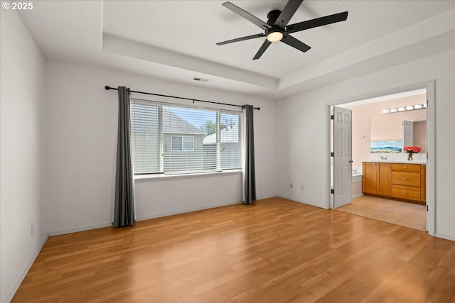 5836 NE Farnham St, Hillsboro, OR 97124 - unfurnished bedroom with light wood-type flooring, a raised ceiling, and baseboards
