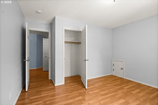 5836 NE Farnham St, Hillsboro, OR 97124 - unfurnished bedroom featuring light wood finished floors, a closet, baseboards, and a textured ceiling