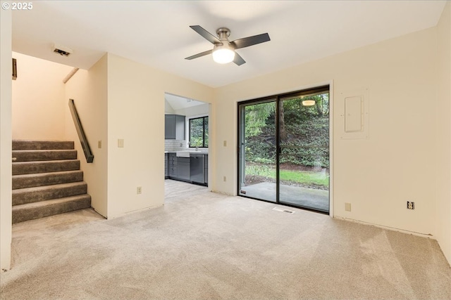 unfurnished living room with light carpet and ceiling fan