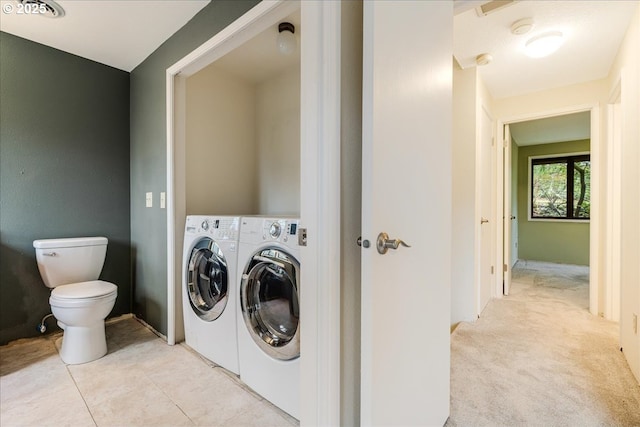 clothes washing area featuring separate washer and dryer and light colored carpet