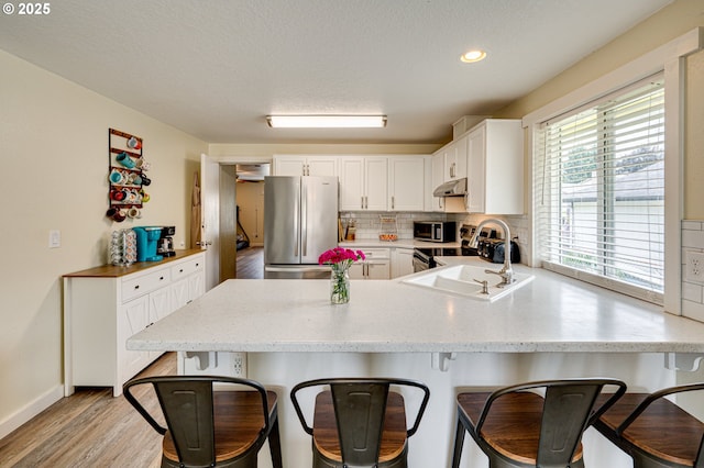 4075 A Loop, Washougal, WA 98671 - kitchen with stainless steel appliances, a sink, under cabinet range hood, a peninsula, and a breakfast bar