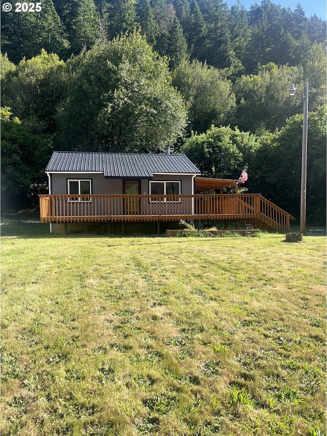 337 Main St, Scottsburg, OR 97473 - rear view of house featuring a deck, a yard, a view of trees, and a metal roof