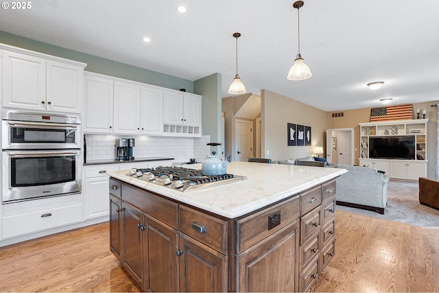 kitchen with light wood-style floors, stainless steel appliances, and white cabinetry