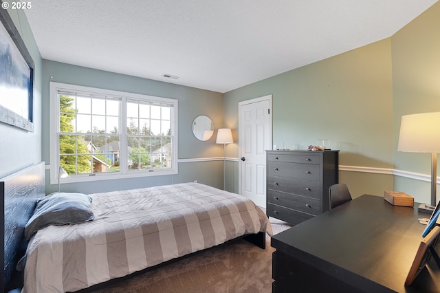 bedroom featuring visible vents and dark carpet