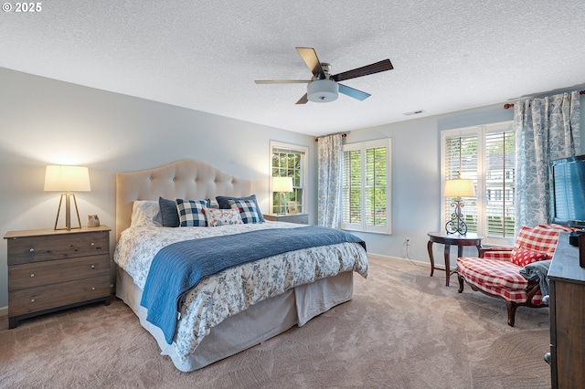 carpeted bedroom featuring baseboards, ceiling fan, and a textured ceiling