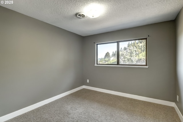 carpeted empty room with baseboards, a textured ceiling, and visible vents