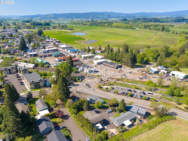 drone / aerial view featuring golf course view and a water and mountain view