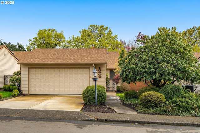 single story home with a garage, roof with shingles, and driveway