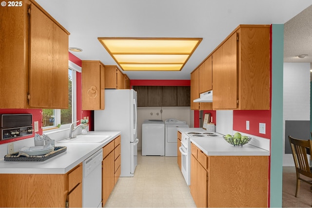 kitchen with washer and dryer, a sink, light countertops, white appliances, and under cabinet range hood