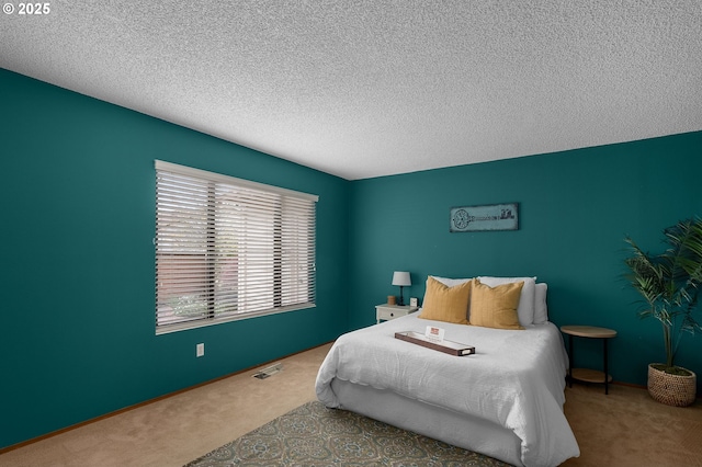 carpeted bedroom with a textured ceiling and visible vents