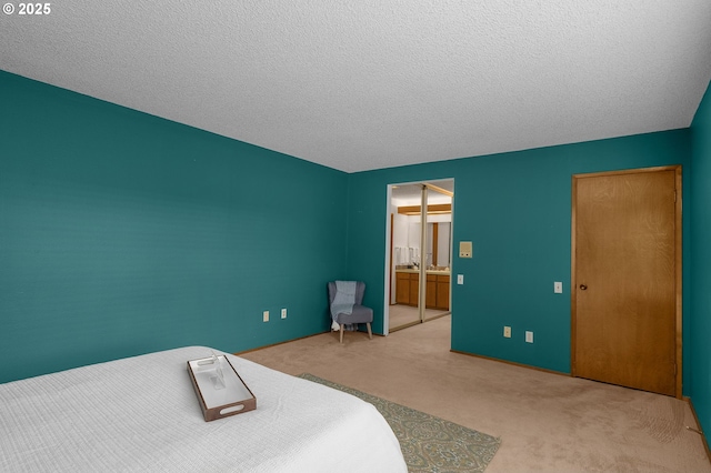 unfurnished bedroom with ensuite bathroom, a textured ceiling, and carpet floors