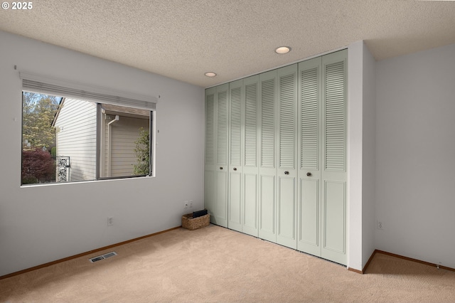 unfurnished bedroom with visible vents, baseboards, a closet, and carpet floors