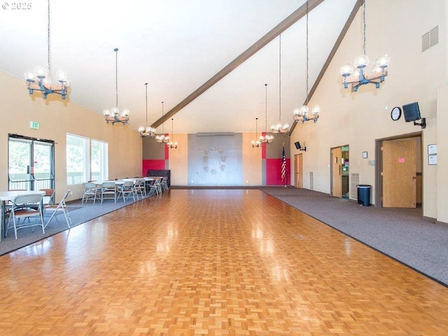 interior space featuring a chandelier, high vaulted ceiling, baseboards, and visible vents
