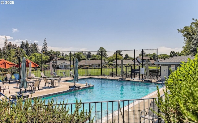 community pool featuring a residential view, a patio area, and fence