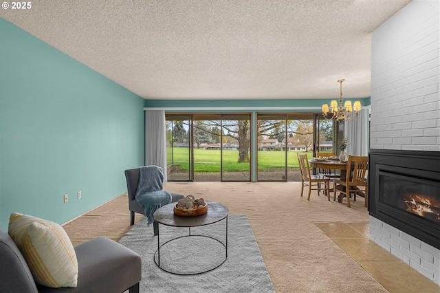 living room with an inviting chandelier, carpet, a fireplace, and a textured ceiling