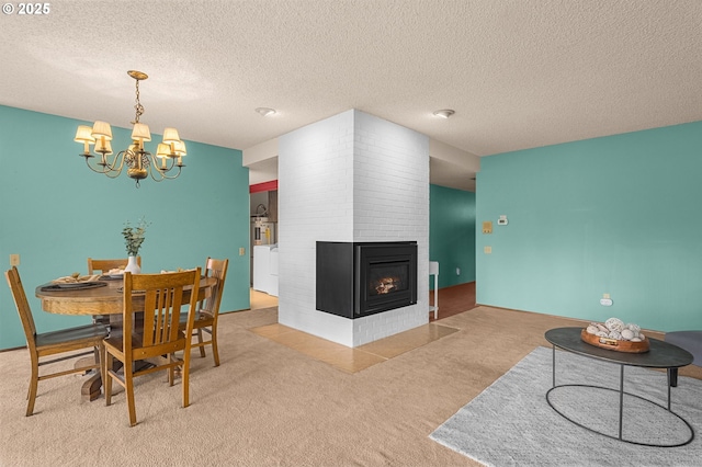 carpeted dining space with washer / clothes dryer, a textured ceiling, an inviting chandelier, and a multi sided fireplace