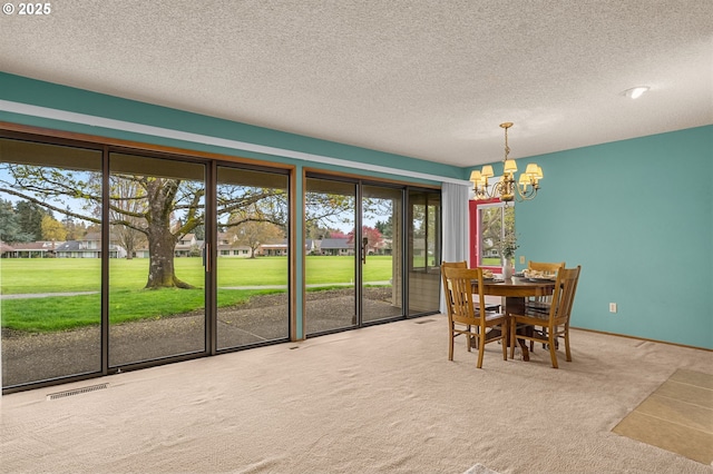 dining space with a textured ceiling, an inviting chandelier, visible vents, and carpet floors