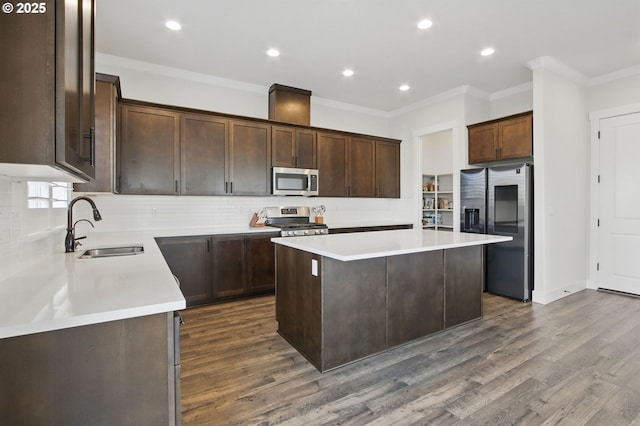 29169 NW King St, North Plains, OR 97133 - kitchen with appliances with stainless steel finishes, a center island, a sink, dark wood-style floors, and ornamental molding