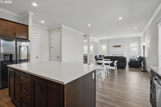 29169 NW King St, North Plains, OR 97133 - kitchen with ornamental molding, wood finished floors, recessed lighting, light countertops, and stainless steel fridge with ice dispenser