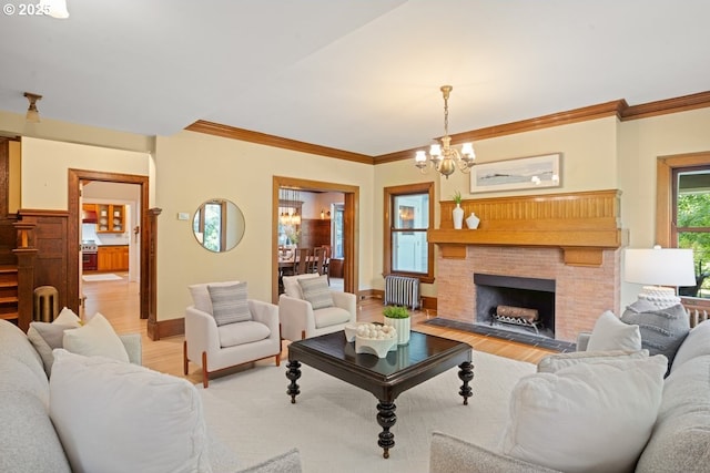 1314 SE 55th Ave, Portland, OR 97215 - living area featuring radiator heating unit, a chandelier, light wood finished floors, ornamental molding, and a fireplace