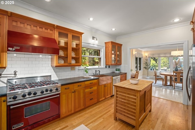 1314 SE 55th Ave, Portland, OR 97215 - kitchen featuring stainless steel appliances, ventilation hood, brown cabinetry, ornamental molding, and tasteful backsplash