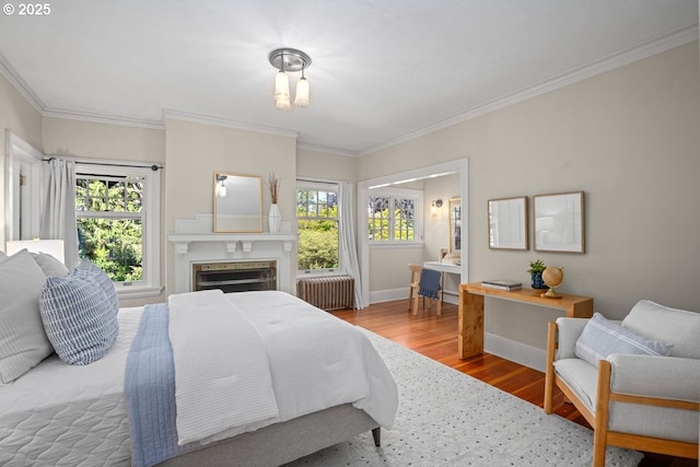 1314 SE 55th Ave, Portland, OR 97215 - bedroom featuring radiator heating unit, wood finished floors, multiple windows, crown molding, and baseboards