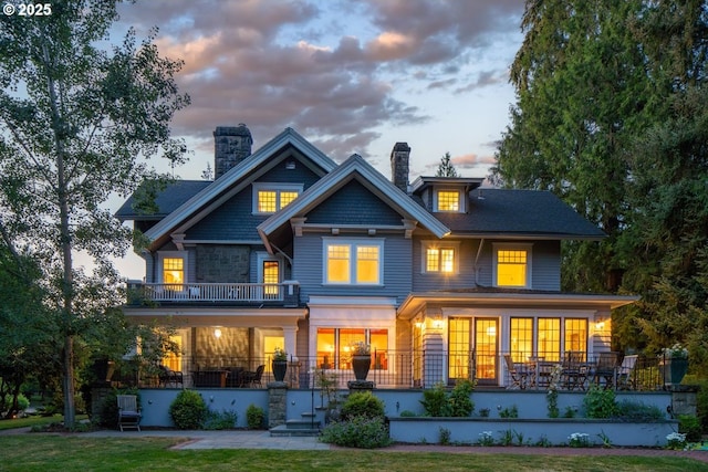 1314 SE 55th Ave, Portland, OR 97215 - back of house at dusk featuring a balcony and a chimney