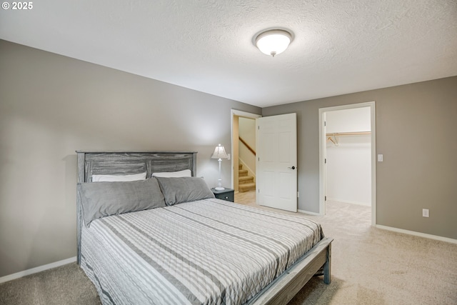 11942 SE Sunny Way, Happy Valley, OR 97086 - carpeted bedroom with baseboards, a textured ceiling, and a walk in closet