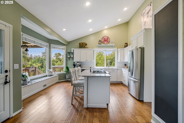 11942 SE Sunny Way, Happy Valley, OR 97086 - kitchen with appliances with stainless steel finishes, a kitchen breakfast bar, tasteful backsplash, white cabinets, and recessed lighting