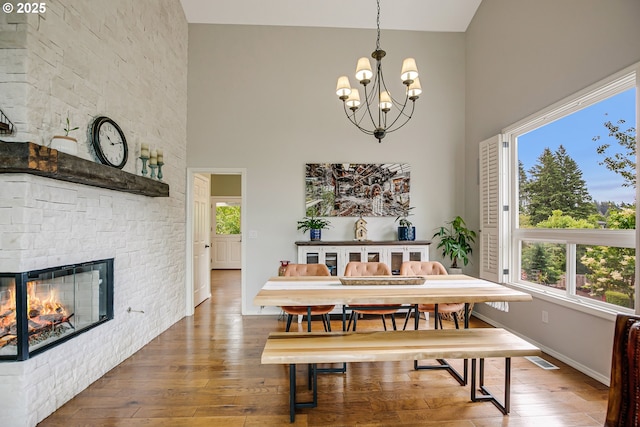 11942 SE Sunny Way, Happy Valley, OR 97086 - dining room with high vaulted ceiling, wood-type flooring, a chandelier, baseboards, and a stone fireplace