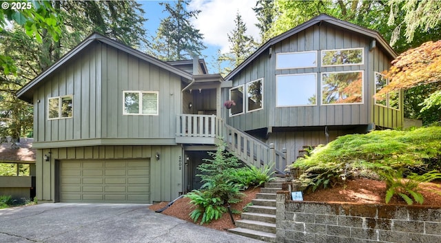 2002 Kimberly Dr, Eugene, OR 97405 - chalet / cabin with stairs, concrete driveway, an attached garage, and board and batten siding