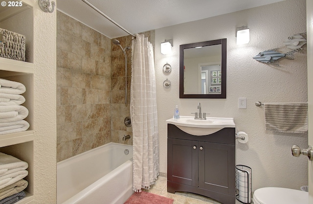 bathroom with vanity, shower / tub combo with curtain, toilet, and a textured wall