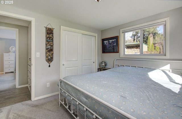 carpeted bedroom with a closet and baseboards