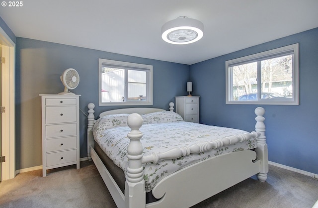 carpeted bedroom featuring multiple windows and baseboards