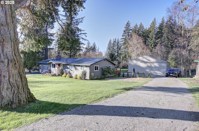 exterior space with gravel driveway, an outdoor structure, a front yard, metal roof, and a chimney