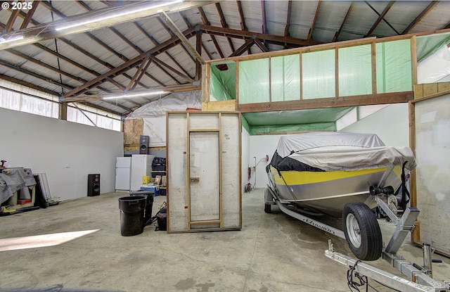 garage with metal wall and freestanding refrigerator