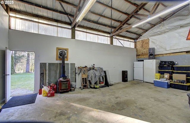 garage featuring metal wall and freestanding refrigerator